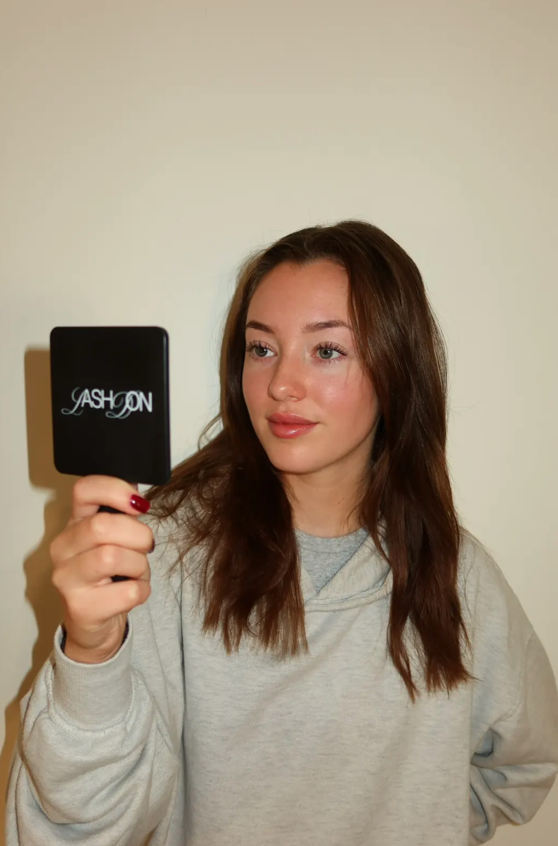 Zoe holding a LashDon compact mirror